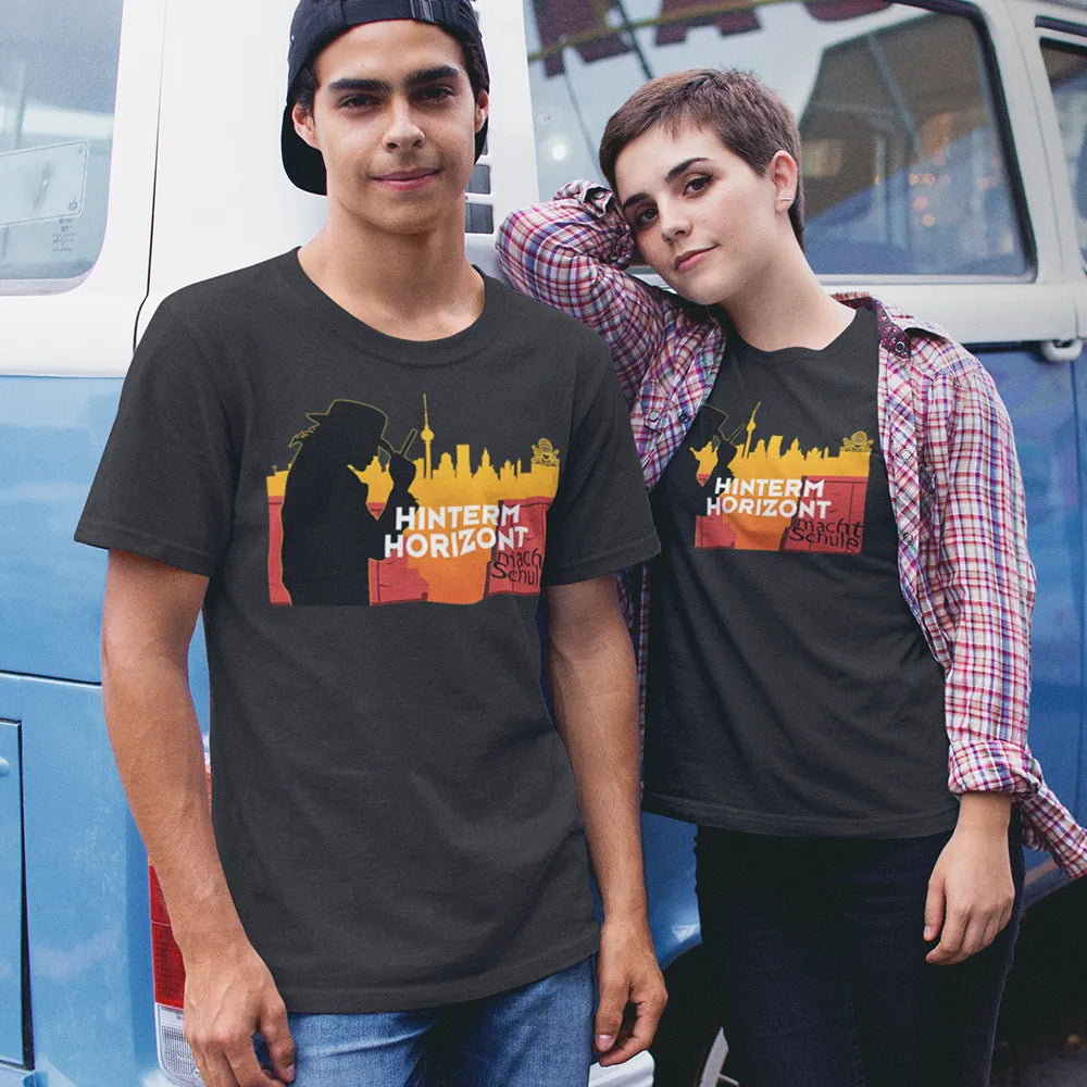 Ein junges Pärchen steht vor einem blauen Bulli und trägt das T-Shirt 'Hinterm Horizont macht Schule'
